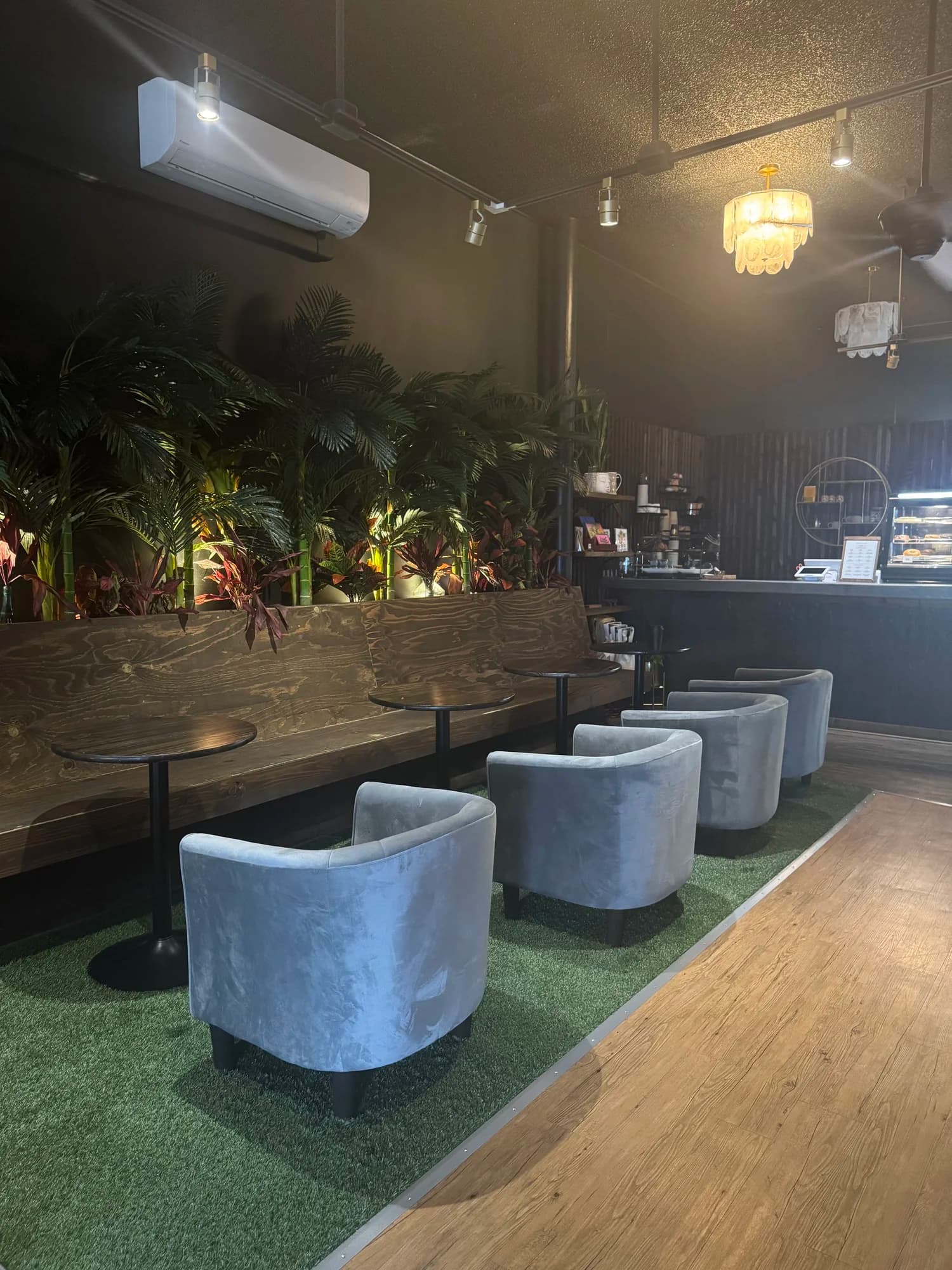 Velvet chairs and plants in the Ānuenue lounge, ready for a private gathering
