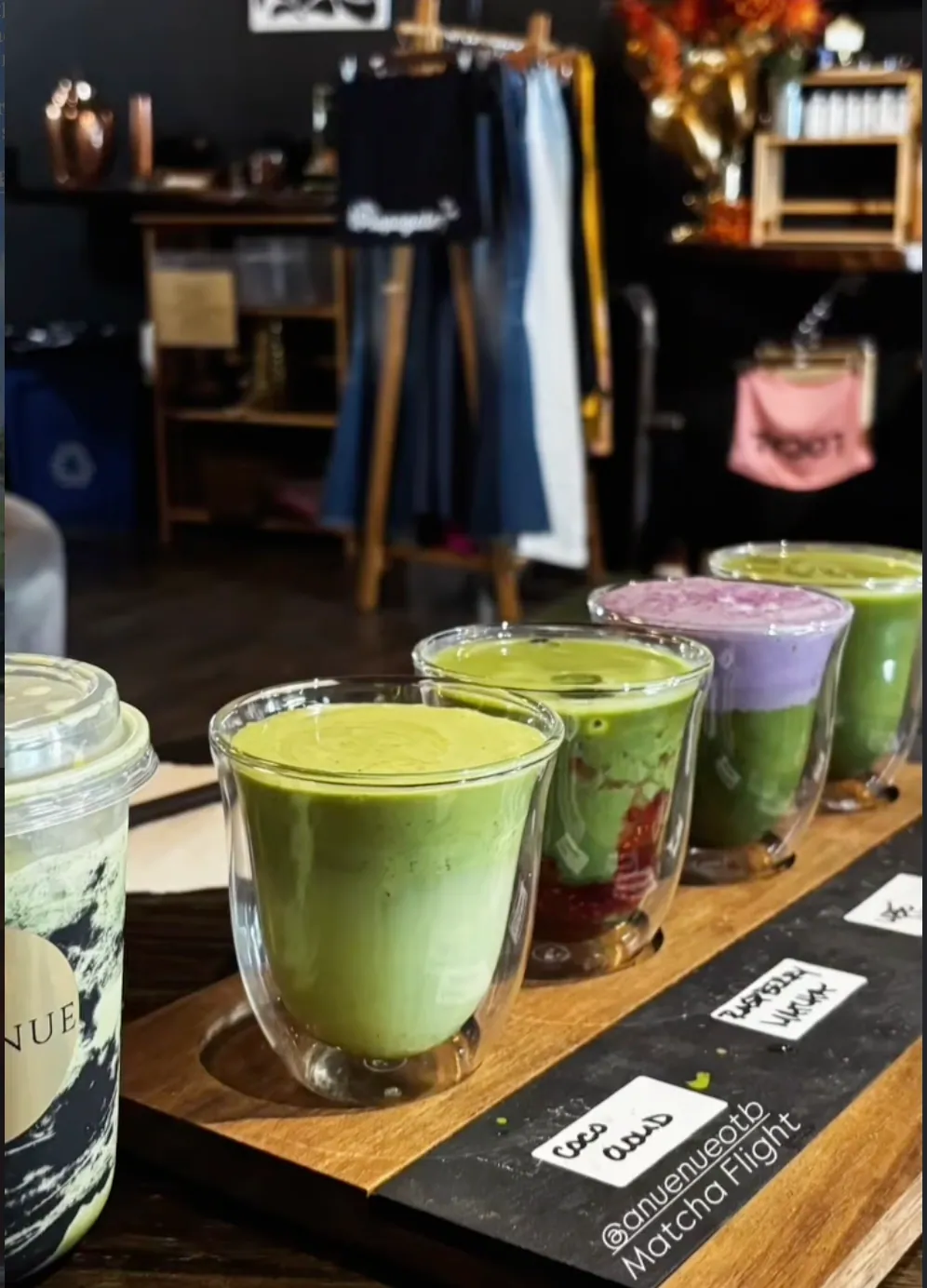 A flight of matcha pours on a wood board, made with our house syrups